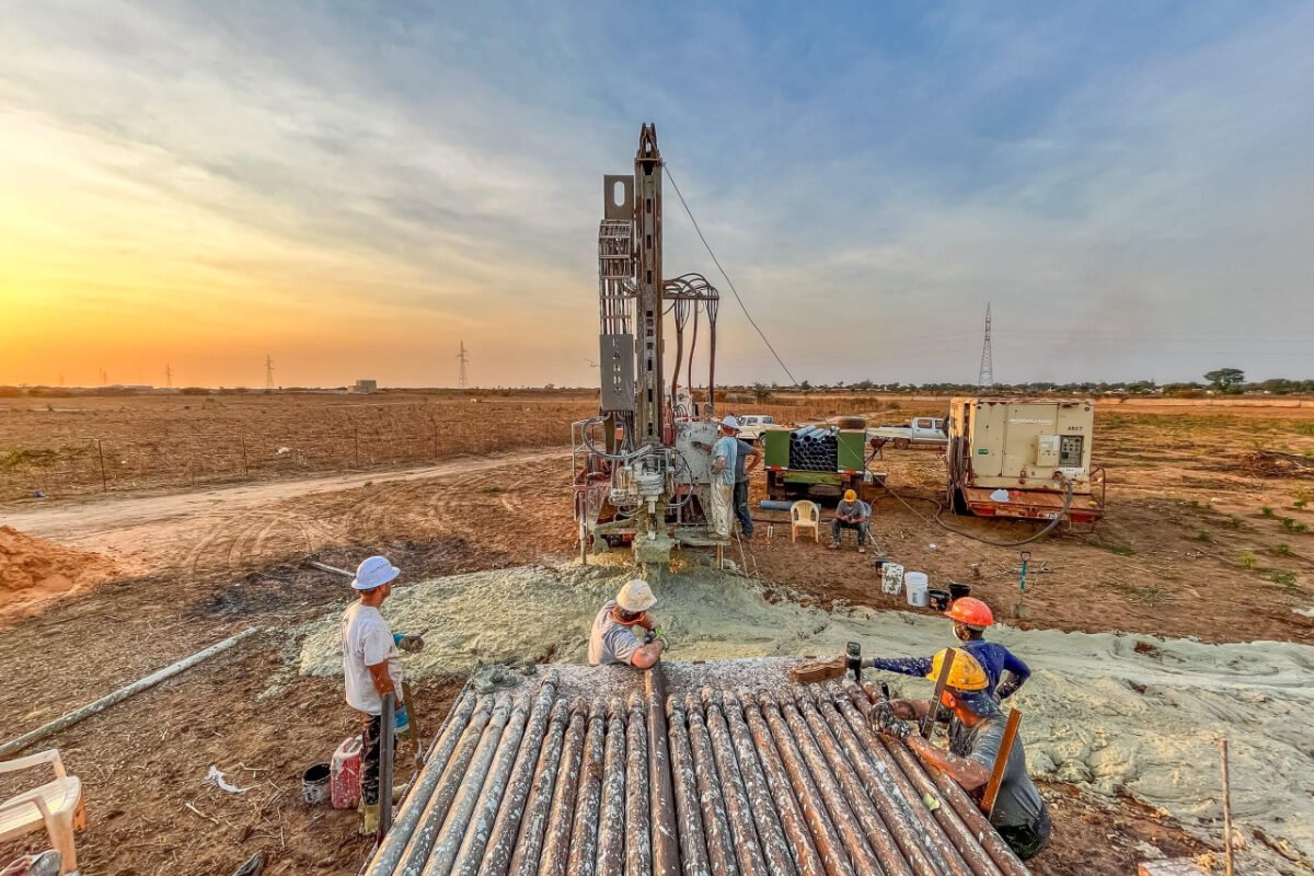 Men with Friends In Action Intl. watch as drilling rig digs hole for well in Senegal West Africa.