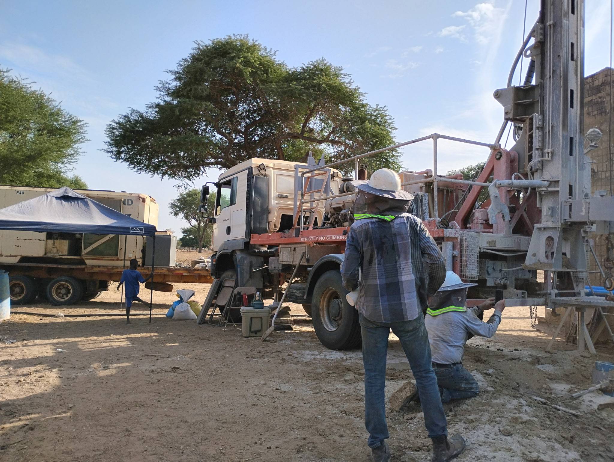Two team members working on the drill rig.