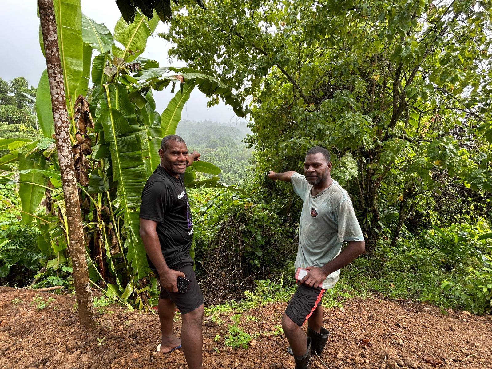 Pastor Gaby (left) and a community member pointing to the terrain.