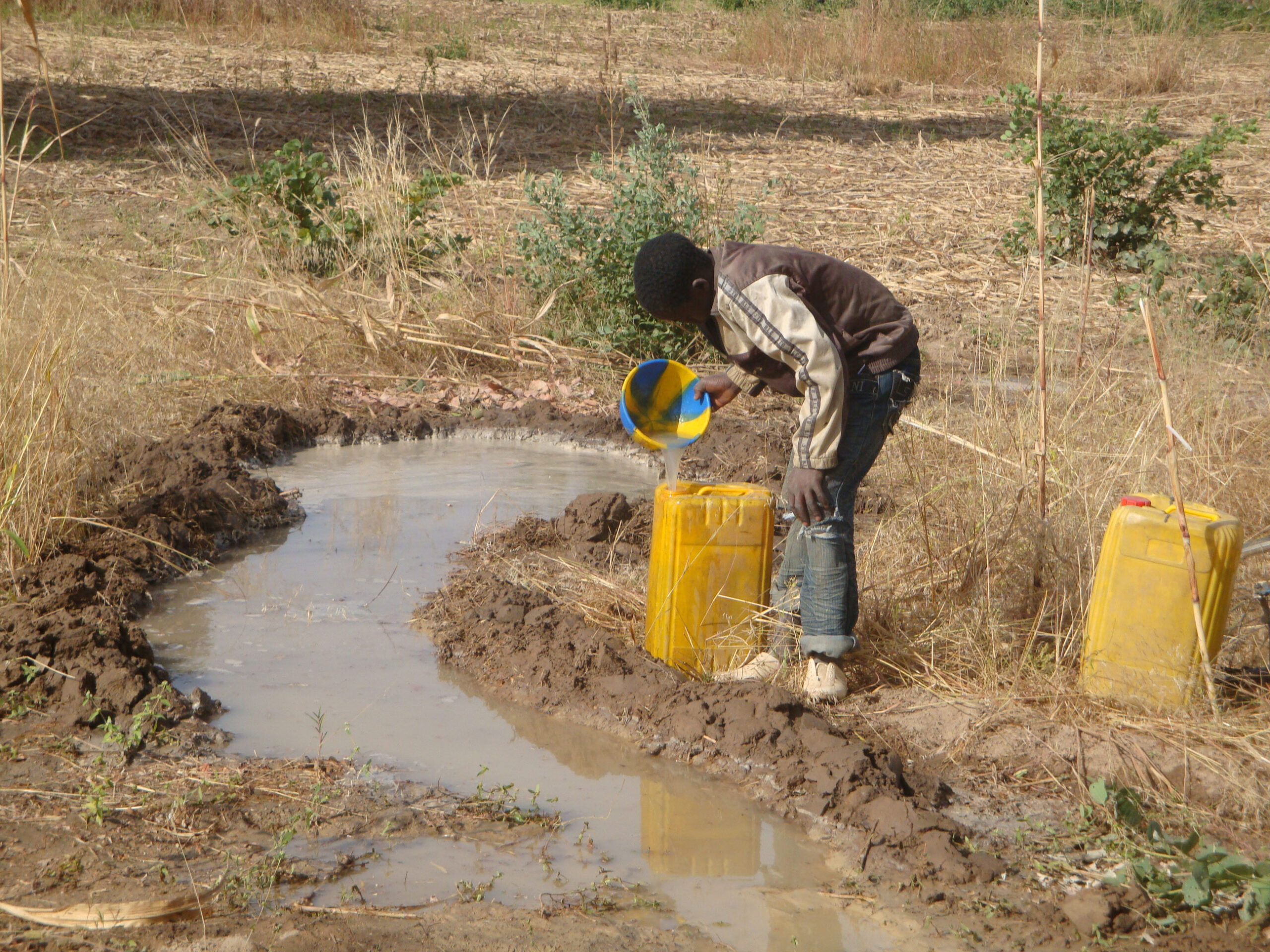A boy collecting the water-drilling run-off.
